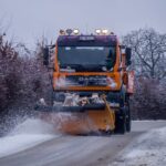 Snow removal truck plowing a snowy street — how to get snow removal customers