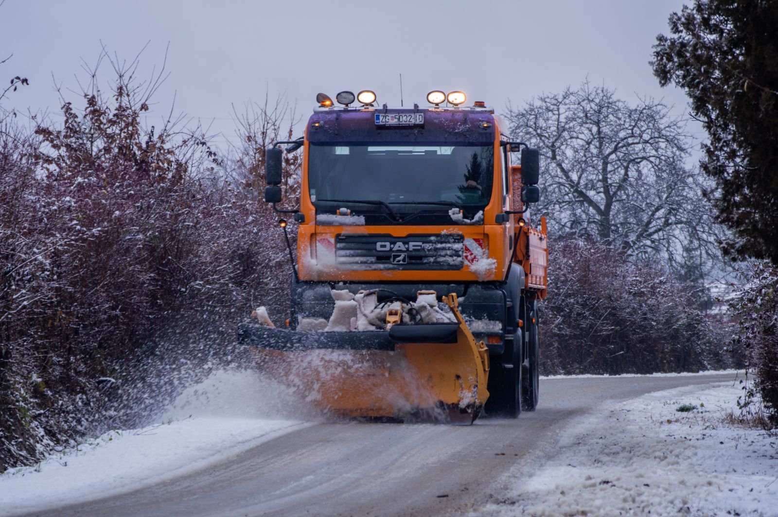 Snow removal truck plowing a snowy street — how to get snow removal customers
